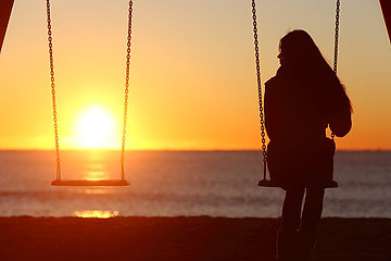 A woman looking at the sunset alone and dealing with a life transition and depressive thoughts after a divorce. Marble Wellness offers therapy and counseling for life transitions, depression, anxiety and much more. 