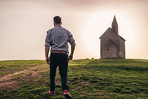 A man walking alone into a church to maintain his faith during a hard time. Marble Wellness offers therapy for men and women dealing with mental health challenges.