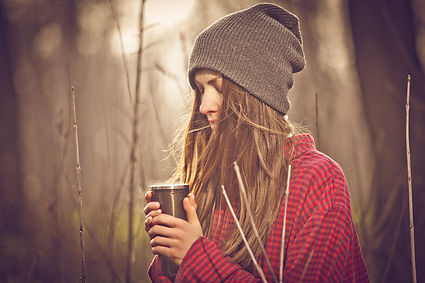 A woman on a walk outdoors with her coffee looking upset and thinking. Marble Wellness offers therapy for break ups in Chicago, IL