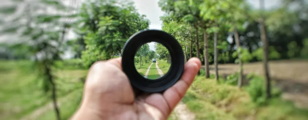 A man holding a focused lens out in nature. Marble Wellness can help you to focus on yourself and make your mental health a priority. Marble Wellness is located in STL and IL and is taking new clients for Anxiety, Depression and more. 