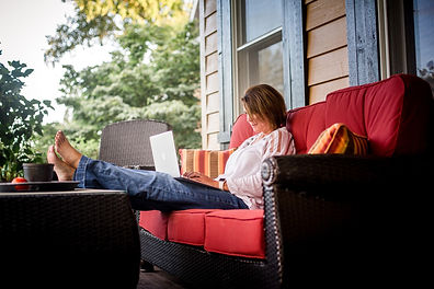 A women sitting in her yard enjoying a beautiful day, relaxed while she talks to her therapist online. Marble Wellness offers Online Therapy for women in Missouri.