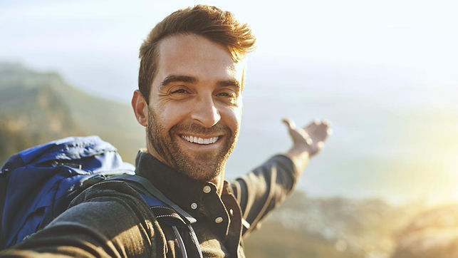 A happy man outdoors smiling and looking at peace. Marble Wellness can help you to be the best version of yourself. Marble Wellness offers Therapy for Men in STL.
