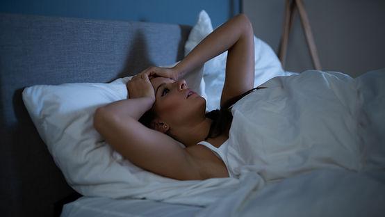 A women not able to sleep. She is in bed at night with her eyes wide open looking frustrated. Marble Wellness is a therapy practice in Chicago, IL and they can help working women get back to feeling peace in their lives. 