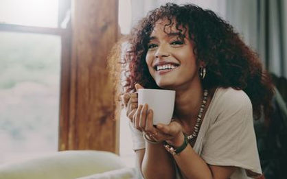 A woman happy and content with where she in in life. She knows her worth. She is smiling with some warm coffee alone and wont settle. Marble Wellness can help you get to this place and offer counseling for men and women in Chicago. 