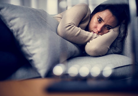 A woman on the couch and being anti-social and isolating herself from family and friends. Marble Wellness can help you cope with Chronic Illness. 