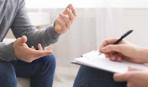 A man talking to his therapist who is taking notes during their session. Marble Wellness has a team of therapists with immediate availability to support clients with anxiety, depression, maternal mental health, kids and teens, and couples. Marble Wellness is in STL 63011.
