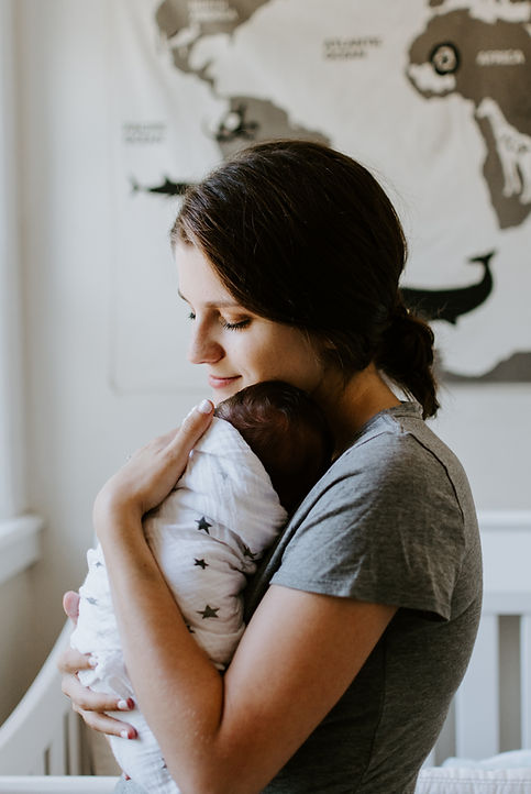 A mom holding her newborn baby. Therapists at Marble Wellness specialize in supporting new moms who have postpartum depression and anxiety.