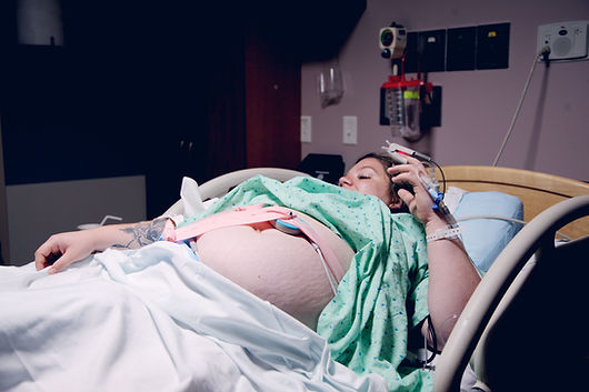 A woman in a hospital bed during labor. Therapists at Marble Wellness in St. Louis support moms who experienced birth trauma.