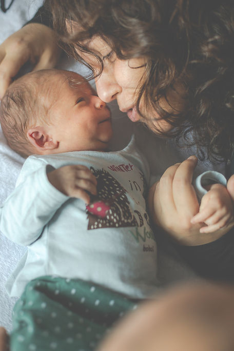 A mom plays with her newborn baby. Therapists at Marble Wellness support new moms with postpartum depression, anxiety, and OCD in St. Louis, Missouri. 