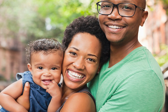 A mom and dad hold their baby. Marble Wellness is a therapist near me in St. Louis, MO that offers counseling for moms, dads, and kids. 