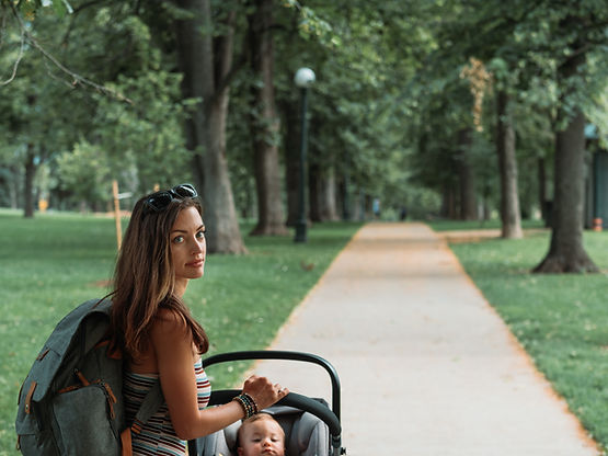 A mom pushes her baby in a stroller. Moms can bring babies in a stroller to see their St. Louis therapist at Marble Wellness for park therapy.