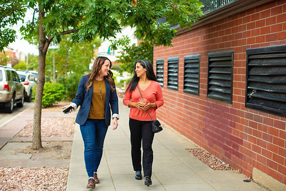 Two women walk through a park. Marble Wellness offers in-person therapy, virtual therapy in Missouri and Illinois, and park therapy to women, men, teens, and kids.