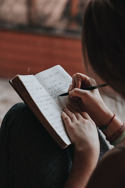 A woman writes in her therapy journal. Journaling is a tool suggested by therapists in St. Louis at Marble Wellness to get the most out of your therapy.