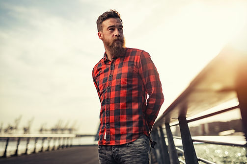 A man in a red shirt stands on a pier in Chicago. Counseling for men is available through Marble Wellness in Chicago and St. Louis. 