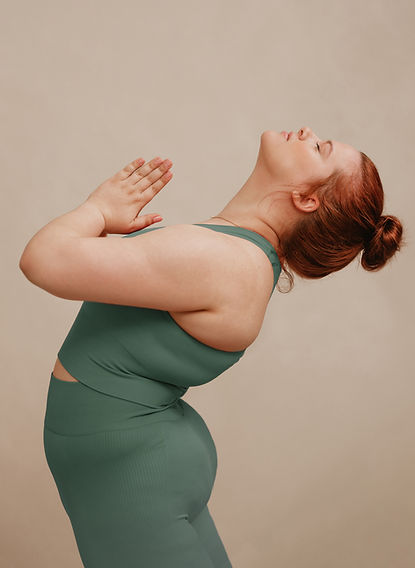 A woman holds a yoga pose. Therapists at Marble Wellness can suggest self-care for moms, and moms can do in-person therapy, virtual therapy, or park therapy.