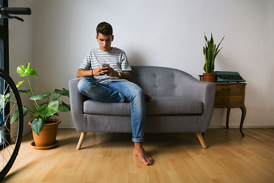 A teen boy looks at his phone while sitting on a couch. Teen boys struggling with substance abuse can find help through teen therapy at Marble Wellness in St. Louis. Therapists in St. Louis, MO 63011 offer teen therapy, family therapy, substance abuse therapy, therapy for parents, and couples therapy. 