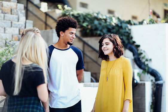 Three teens talk outside of a building. In-person therapy for teens, online therapy for teens, and park therapy for teens are specialties of Marble Wellness, a counseling practice in west county St. Louis, MO 63011. 