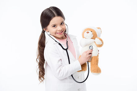A girl holds a stethoscope to a teddy bear's chest. Marble Wellness, a therapist near me in Ballwin, MO 63011 offers therapy for children and teens.