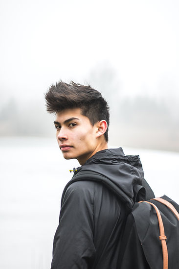 A teenage boy in a black jacket looks over his shoulder. Marble Wellness, a therapist near me, specializes in therapy for teen boys in St. Louis, MO 63011. In-person therapy in St. Louis and online therapy in Missouri are available. Get in touch today to start therapy for teens!