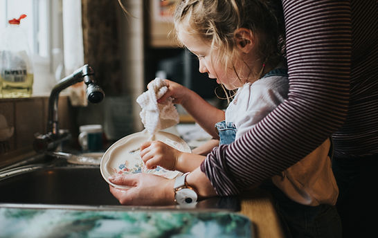 A young girl helps wash dishes in the sink. Child therapy, also called play therapy, can help kids learn independence and responsibility. Child therapists in St. Louis at Marble Wellness can help your family through the new school year.