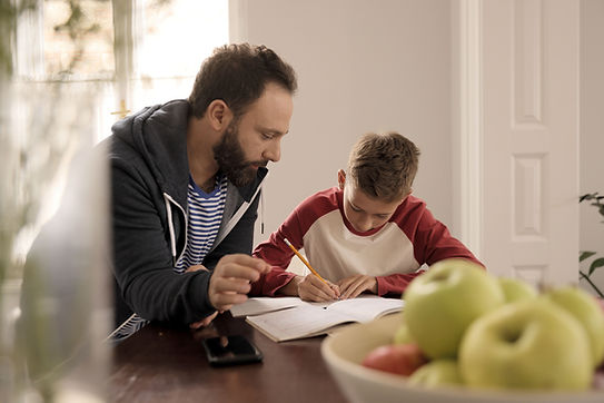 A dad helps his son with homework at a table. Father-child relationships are critical for mental health, and therapy for men in St. Louis is available to help men strengthen these relationships. Marble Wellness therapist Skyler Martin specializes in therapy for dads in St. Louis, MO 63011.