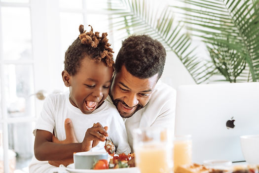 A dad and son make a meal together. Therapy for dads in St. Louis is available to help fathers process stress in parenting. Marble Wellness offers in-person therapy, online therapy, and park therapy.