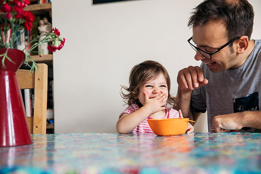 A dad eats a snack with his daughter at a table. Marble Wellness specializes in therapy for men in West County, MO. Our Ballwin therapy practice offers therapy for dads to help strengthen bonds with their children.