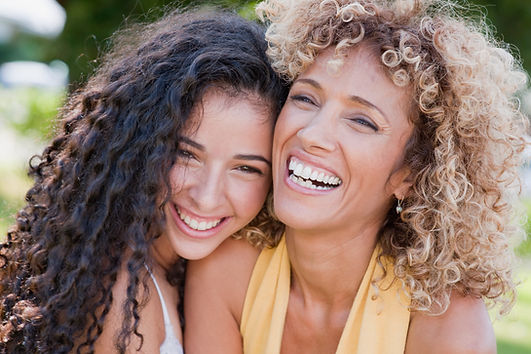 A teenager daughter and her mom laugh together. Therapy for moms, therapy for teenagers, and family therapy are specialties of Marble Wellness in St. Louis, MO. 