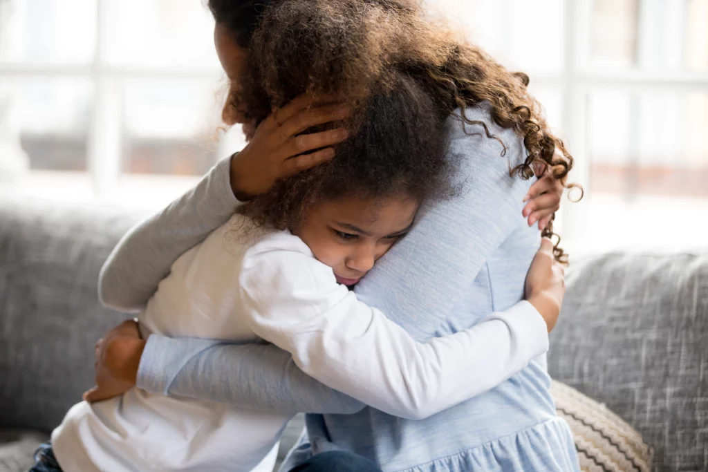 A mother comforting her child while hugging. Marble Wellness can help support relationships and families dealing with grief, tragedy or trauma. 