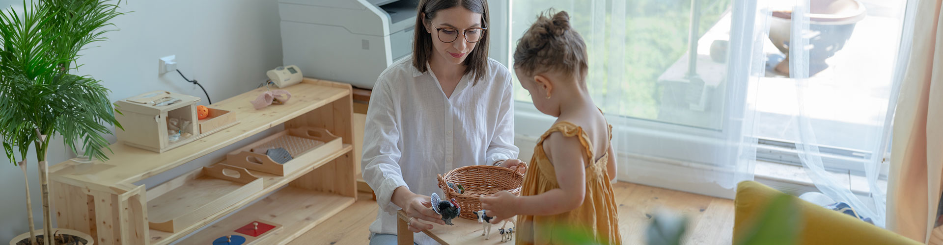 Photo of a therapist and a child doing exercises and playing together with toys at the beginning of a therapy session. You can your child can feel better and have more and better quality time together with child therapy in St. Louis with Marble Wellness.