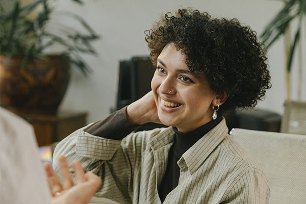 Photo of a woman with a happy and relaxed expression sitting in a therapy office. You can start to live a life free from depression with counseling for depression in St. Louis, MO at Marble Wellness 63011.