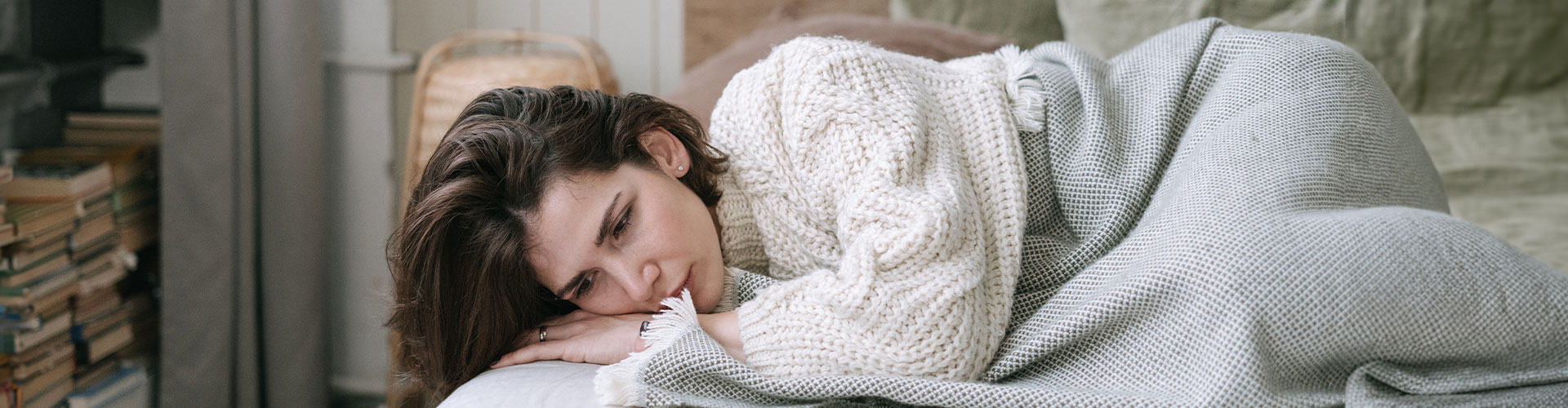 Photo of a woman lying in bed lost in thought, with a sad expression. There is hope after depression treatment in St. Louis, MO, and after counseling for depression in St. Louis, MO at Marble Wellness 63011.