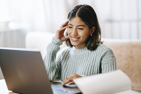 Photo of a young woman smiling at the computer talking to her Illinois online therapist. You can get online therapy in Chicago, IL with an online counselor. It's important to find a good fit for online therapy for women in Illinois.