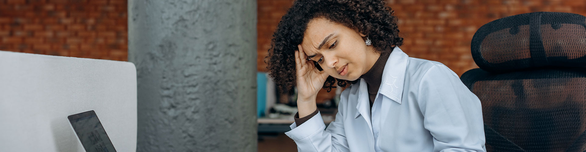 Photo of a woman stressed and overwhelmed at work. Therapy for work burnout in Chicago, IL | occupational stress | stress and burnout in healthcare professionals | corporate burnout | in-person therapy | 63122 | forrest glen 60630 | Lincoln Park is 60614 | north center 60613 | 60618.