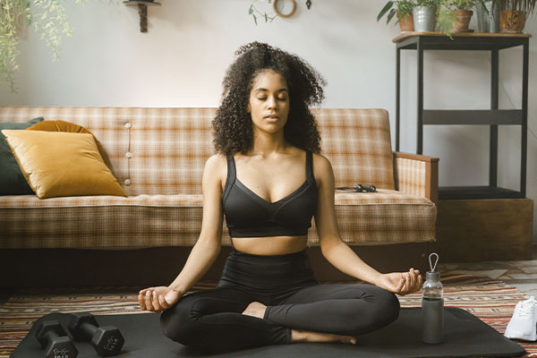 Photo of a woman trying to manage her anxiety on her own with yoga. Anxiety, stress and worry can be addressed in therapy in St. Louis at Marble Wellness. Virtual therapy in Missouri can help with your anxiety and stress too!