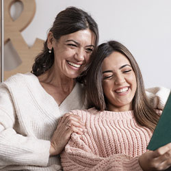 Photo of a mother and teen daughter enjoying each other company while the daughter is reading a book. Get counseling for moms of teens in St. Louis, MO with STL therapist Stephanie. Get the help you need with online therapy in Missouri and online counseling in Saint Louis, MO.