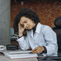Photo of a woman stressed and overwhelmed at work. Therapy for work burnout in Chicago, IL | occupational stress | stress and burnout in healthcare professionals | corporate burnout | in-person therapy | 63122 | forrest glen 60630 | Lincoln Park is 60614 | north center 60613 | 60618.