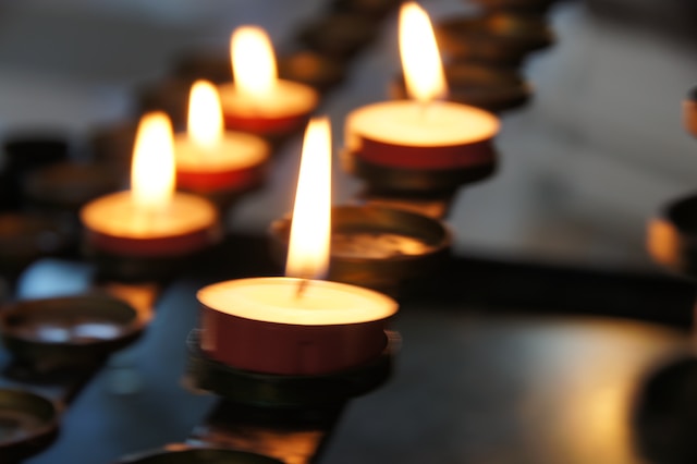 Lit tea light candles representing shedding light on common grief misunderstandings and challenges. Marble Wellness grief counselors are here to help you on your journey.