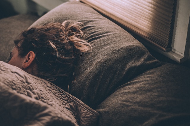 A girl under the covers sleeping. Sleep disturbances can be a sign of anxiety.