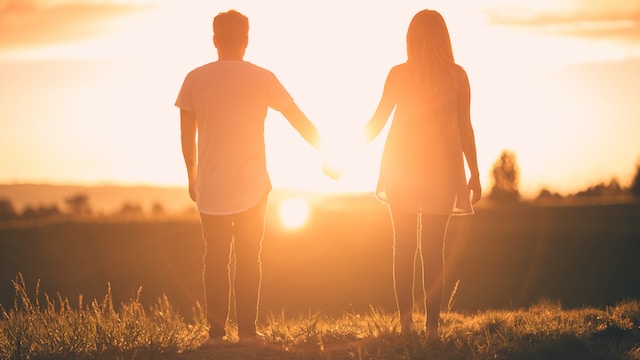 A girl and boy stand outside holding hands while the sun sets. Couples and marriage therapy in St. Louis can help connect with your partner. Reach out today to set up an appointment.