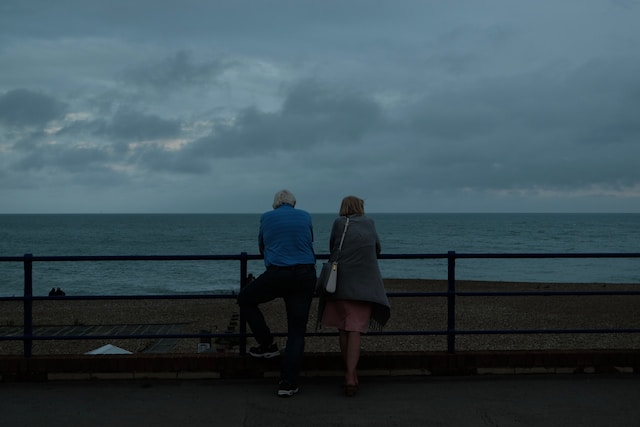 Older couple on a gloomy day looking out at the beach with an ocean view. Couples counseling can help resolve conflict and deeper your connection. Marble Wellness offers couples counseling, we are here to help.