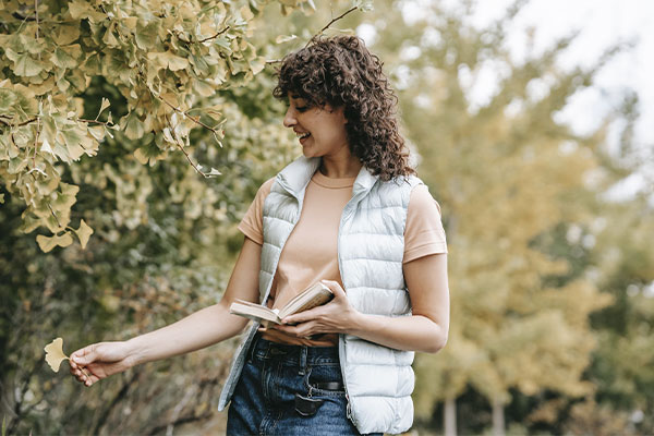 Photo of a woman walking in the park with a happy and relaxed expression. You can start to live a life free from therapy for depression in Chicago, IL in Marble Wellness.