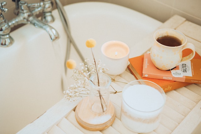 A relaxing bath with hot tea, flowers and a lit candle. Self-care is important post break-up. For more tips and talk with a St. Louis therapist today call Marble Wellness.