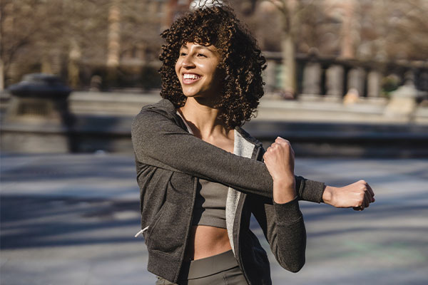Photo of a woman exercising, feeling happy and confident. You can overcome stress, worry and anxiety with therapy in Chicago, IL at Marble Wellness.