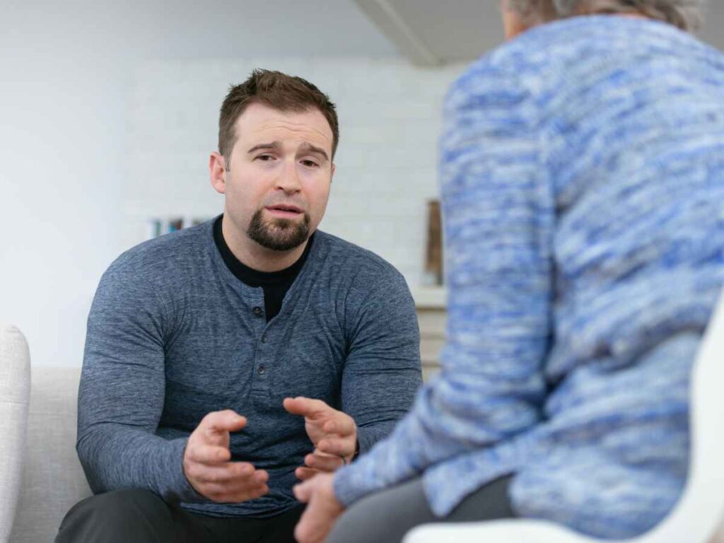 Man in therapy looking thoughtful while explaining something. Marble Wellness is a therapy practice in West County, MO offering counseling for men's mental health.