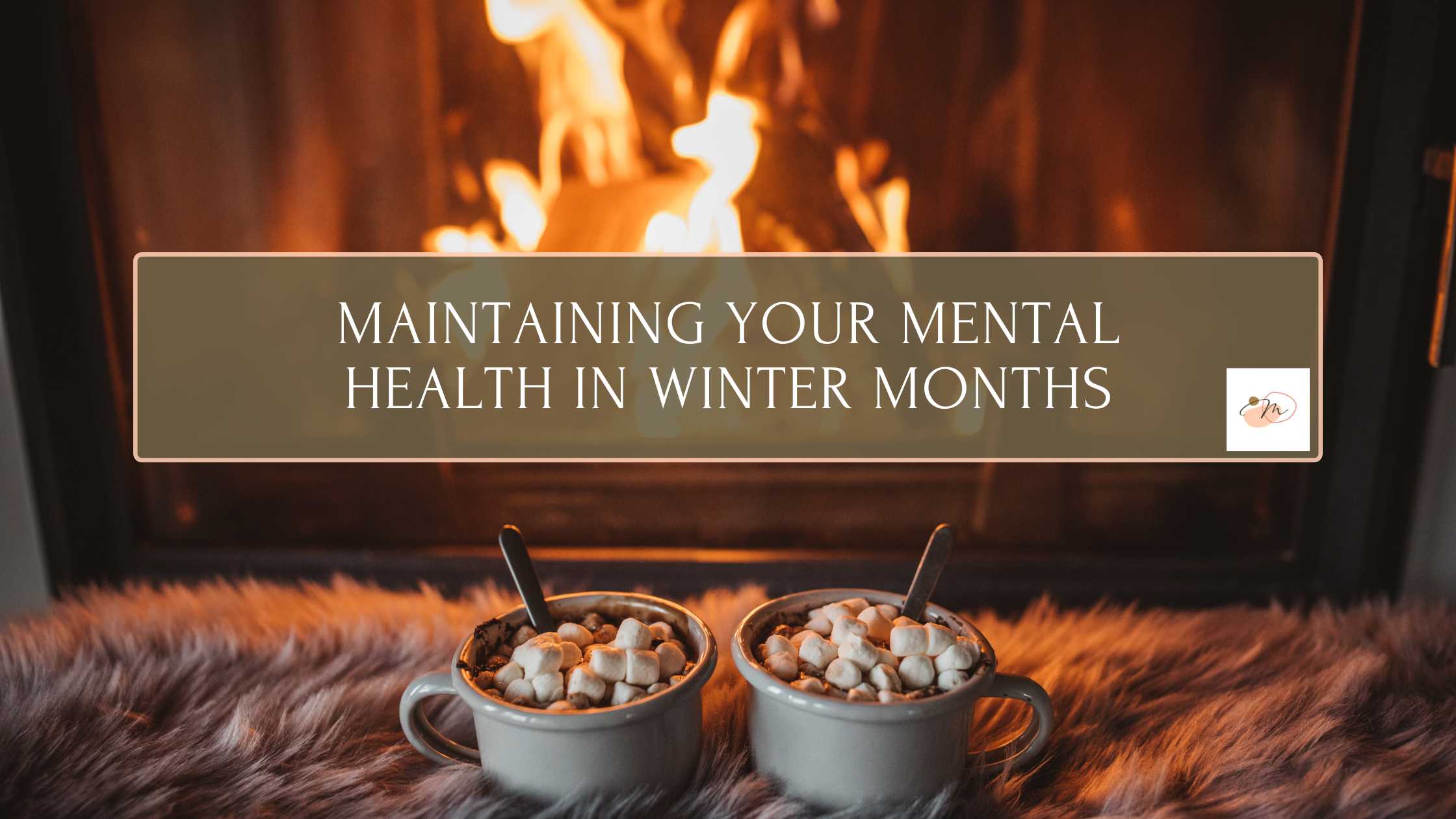 Two cups of hot cocoa with marshmallows with a fireplace in the background. Blog post cover for "Maintaining Your Mental Health in Winter Months" from a STL therapy practice for moms, dads, teens, kids, couples and more.