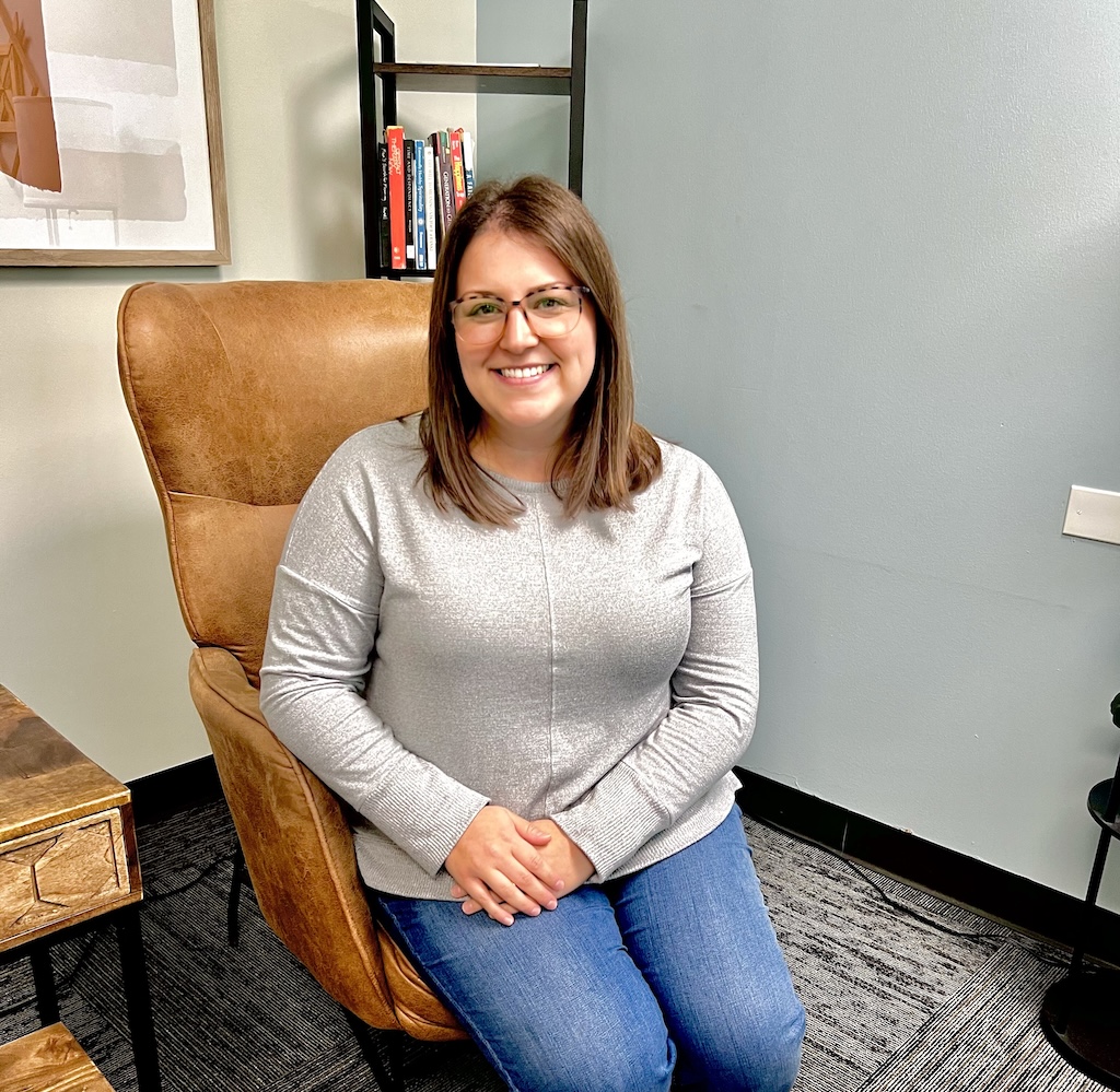 Marble Wellness Therapist Shayla, sitting in a chair looking at the camera. Meet with a Missouri online therapist for children, teens young adults, moms and more here!