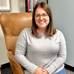 Marble Wellness Therapist Shayla, sitting in a chair looking at the camera. Meet with a Missouri online therapist for children, teens young adults, moms and more here!