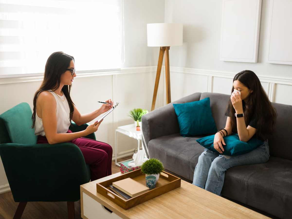 Young woman with PTSD sitting in trauma therapy talking with a trauma therapist in Ballwin, MO. You can also get online trauma therapy in Missouri with an online PTSD therapist here.