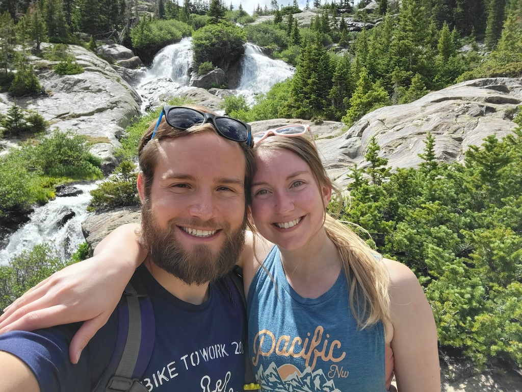 Marble Wellness Therapist Katie, standing with husband near trees looking at the camera. Meet with a Missouri online therapist for children, teens young adults, moms and more here!